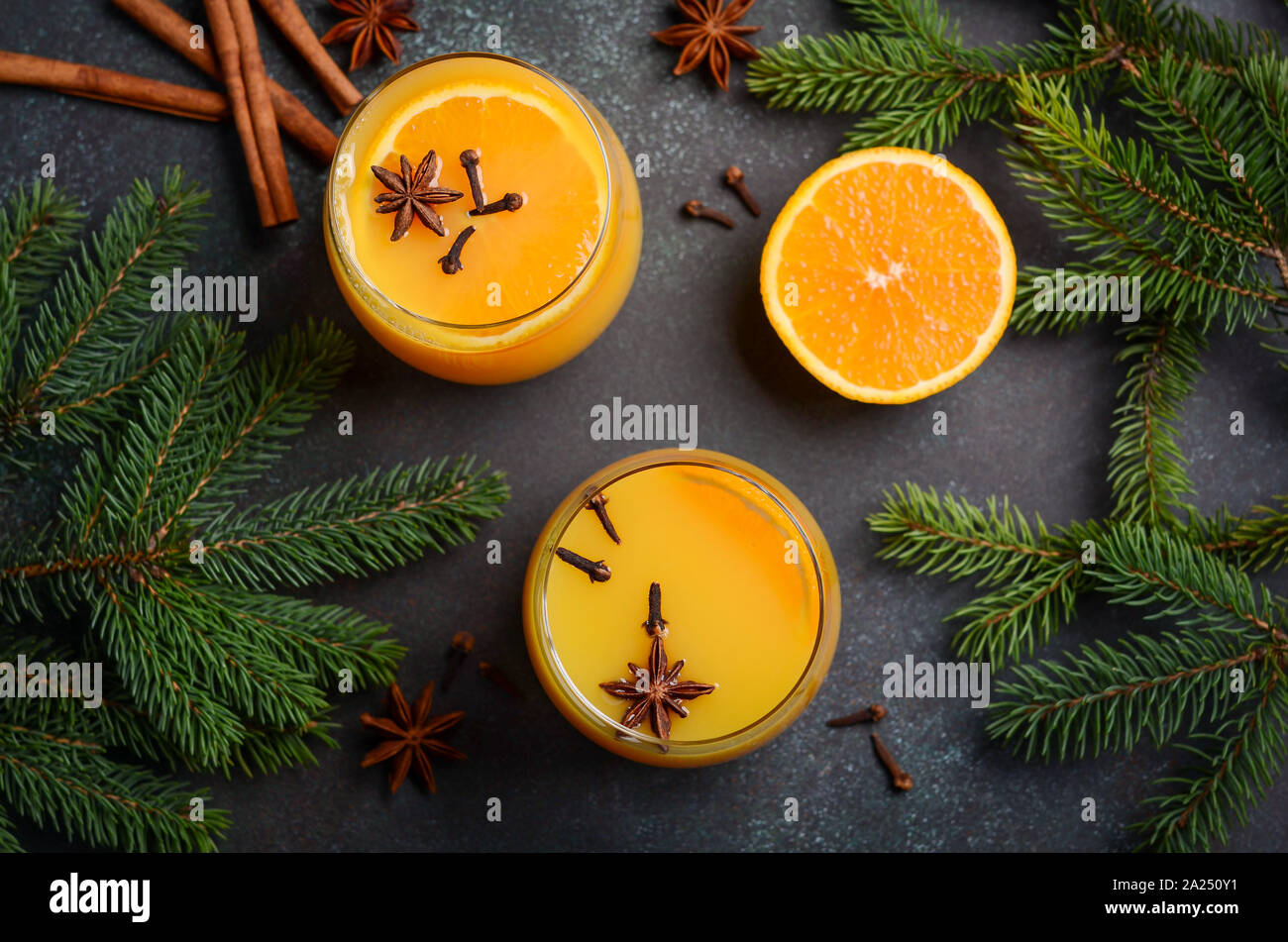 Fall Winter Cocktail Hot Spicy Orange Punch with Spices. Holiday Concept Decorated with Fir Branches and Spices. Stock Photo