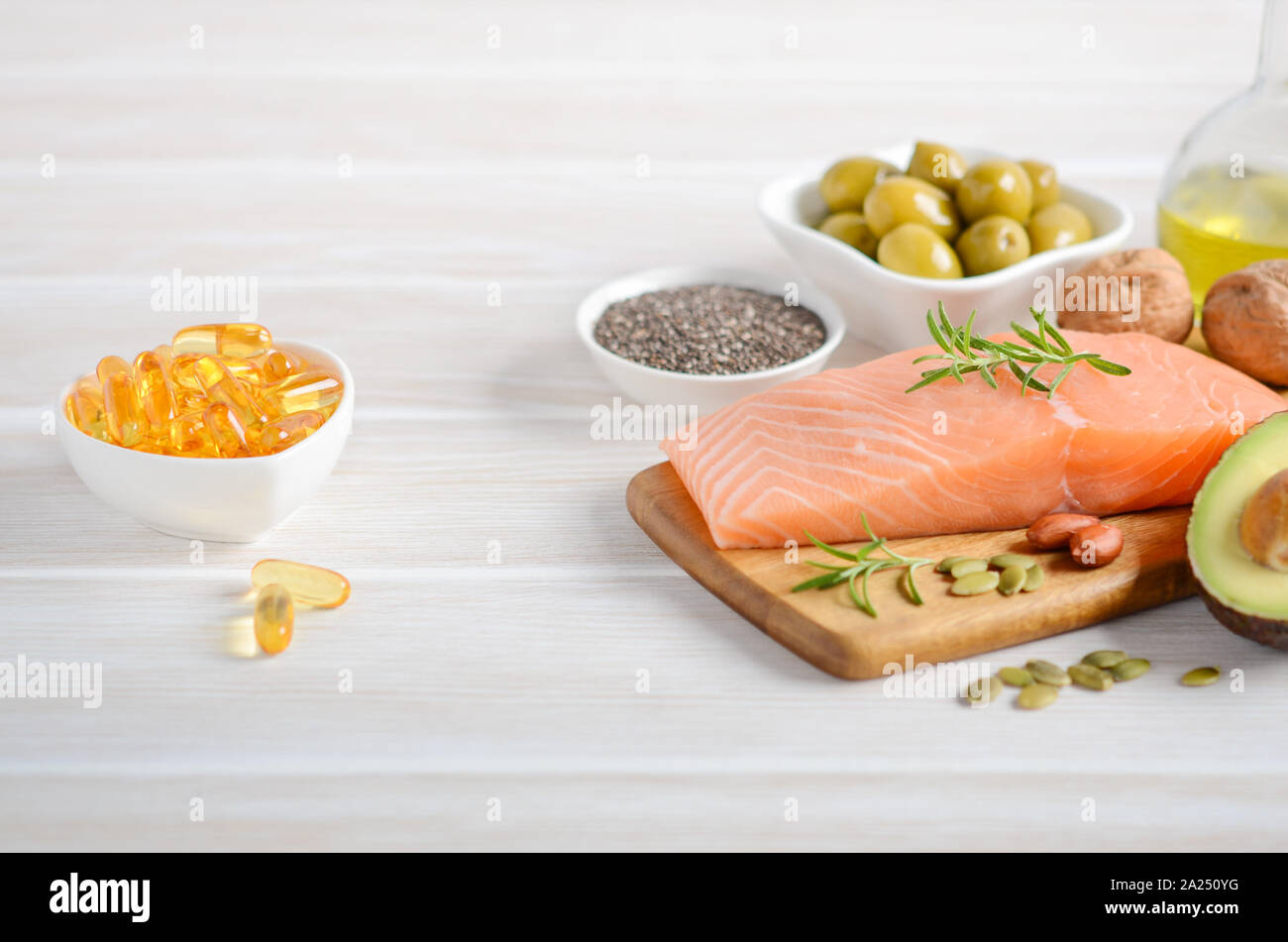 Selection of healthy unsaturated fats, omega 3 - fish, avocado, olives, nuts and seeds. Stock Photo