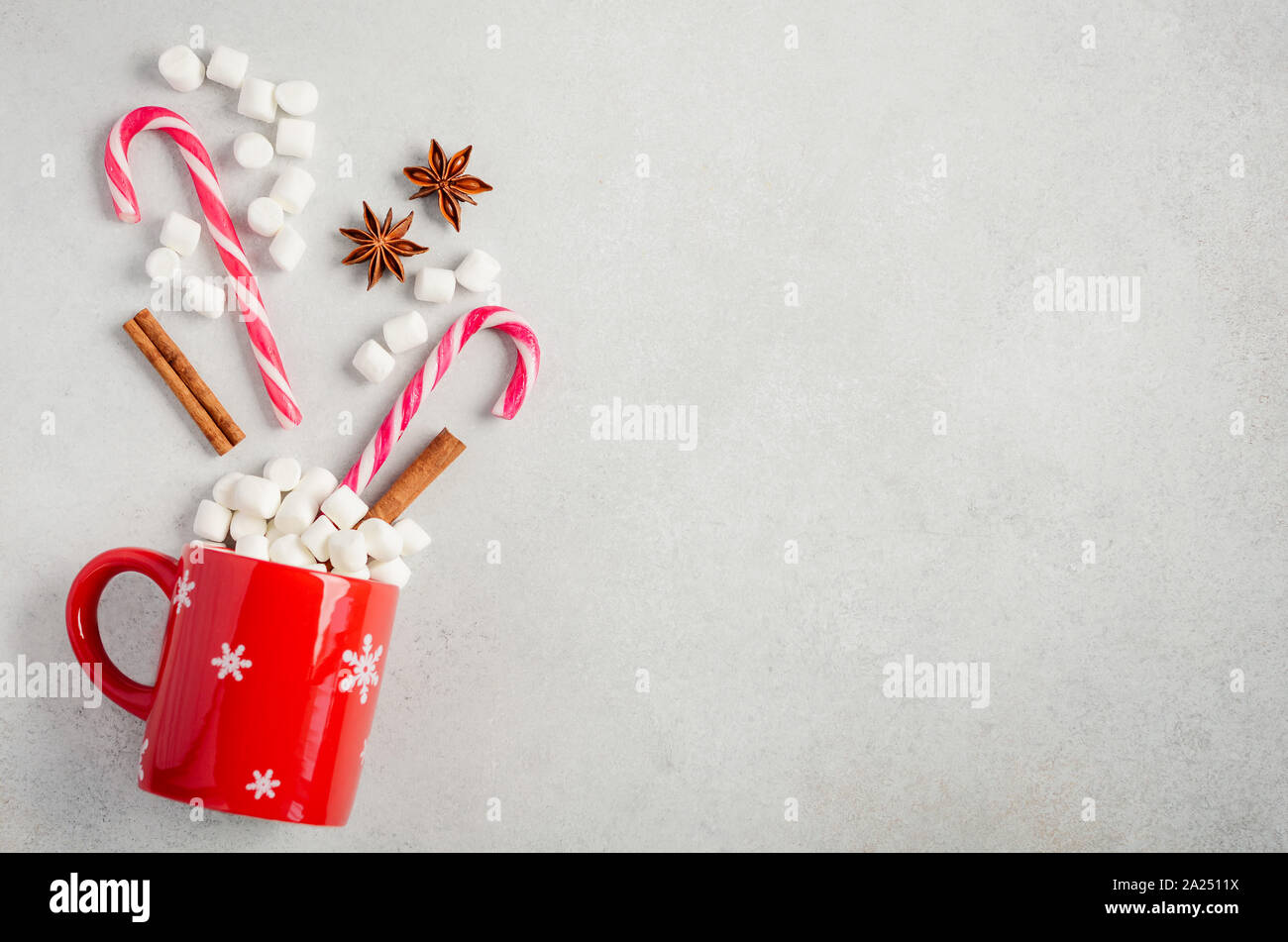 New Year or Christmas concept. Composition with marshmallows and candy canes on a gray concrete background. Top view, flat lay, copy space. Stock Photo