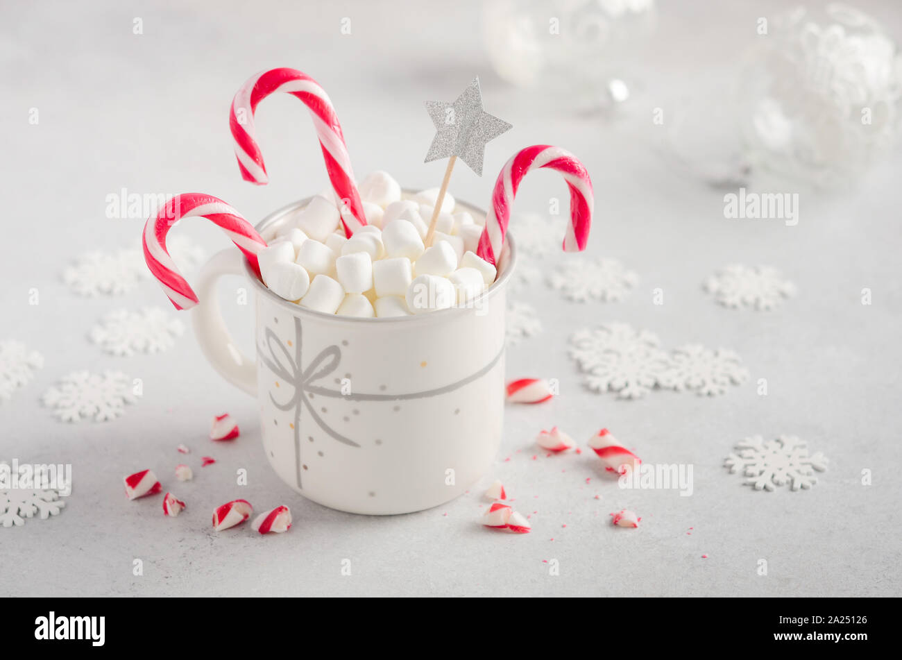 New Year or Christmas concept. Composition with marshmallows and candy canes on a gray concrete background. Stock Photo