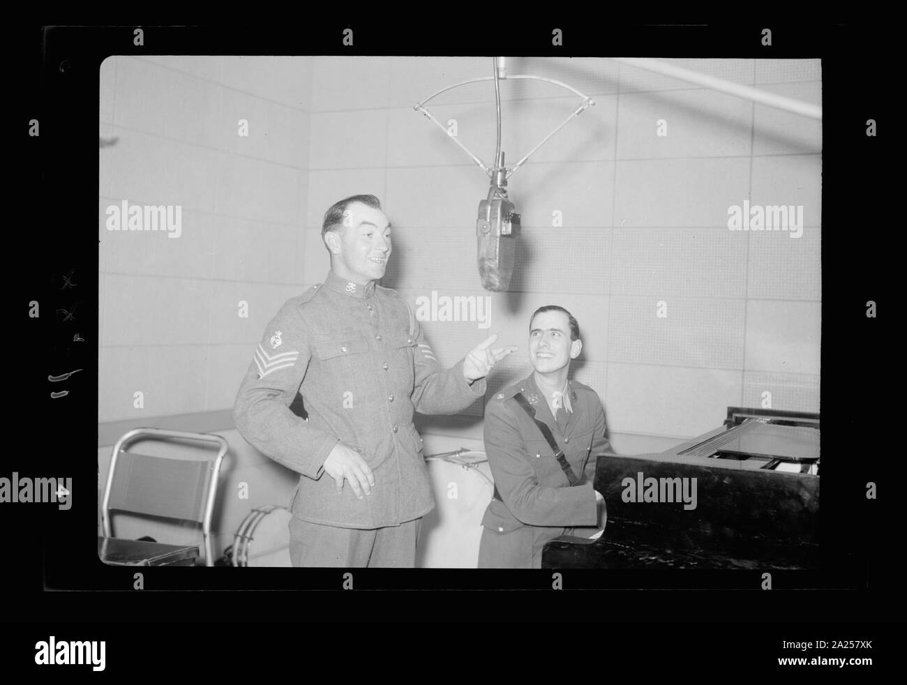 Photo taken in Palestine Broadcasting Service Studios, Jerusalem. Sergeant ... at mic. i.e., microphone, Lt. Watson at piano Stock Photo