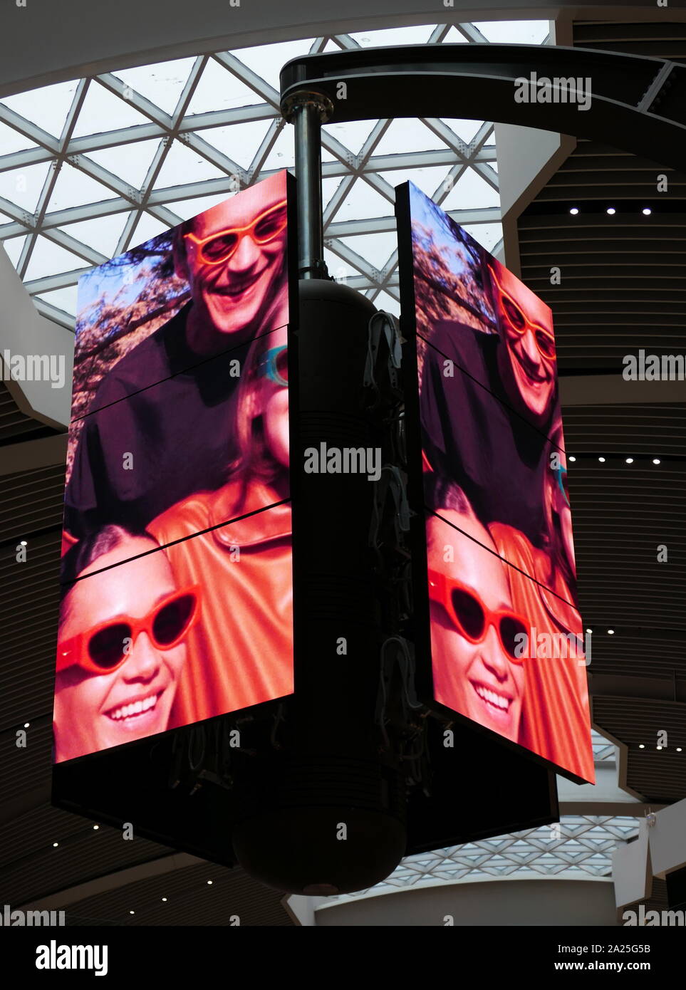 A bank of digital television screens in the departures terminal of Rome–Fiumicino International Airport . The screens display sequential adverts on a regular cycle in which both adverts and screens rotate shift and re-align to create multiple or grouped images. Stock Photo