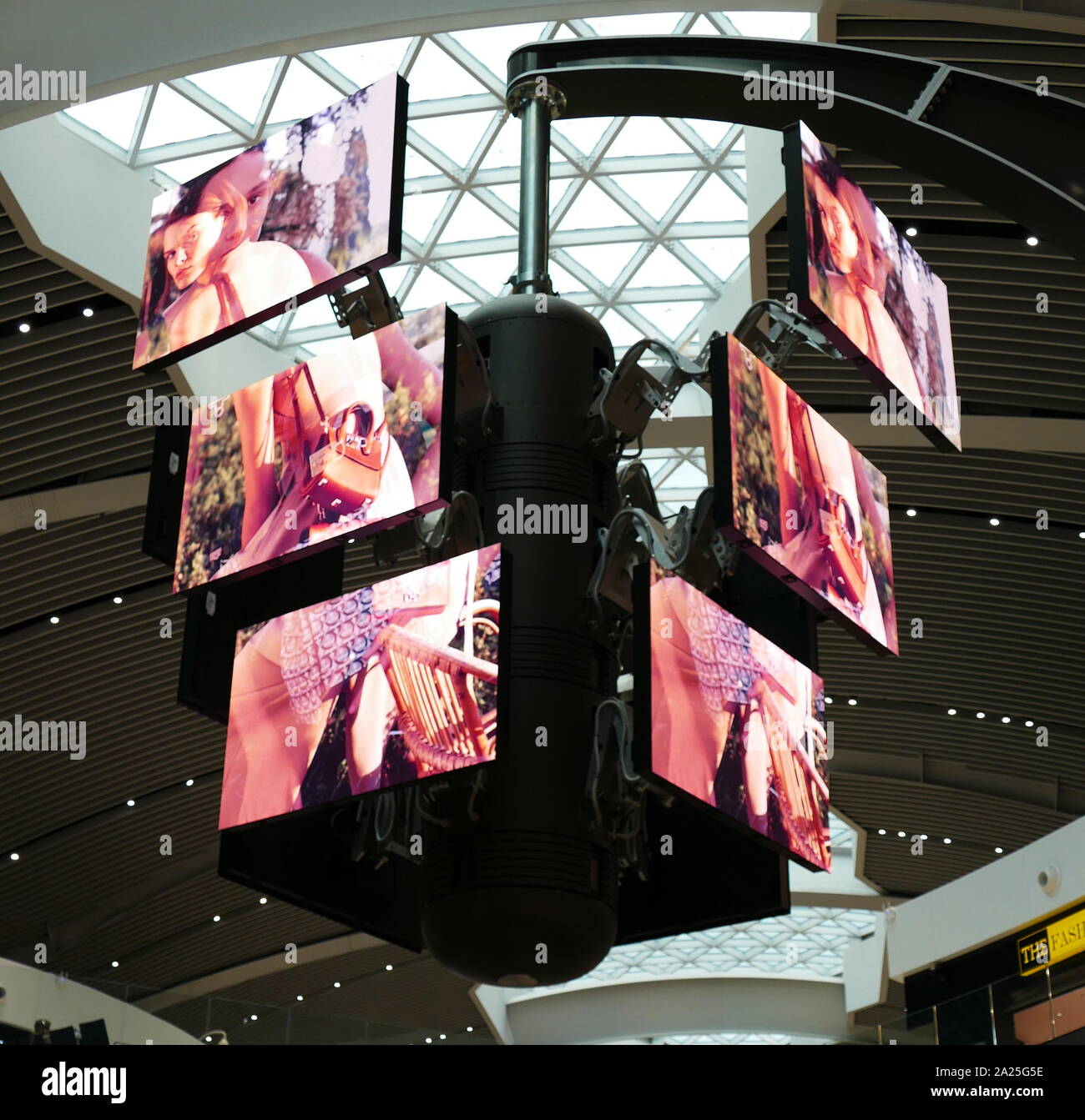 A bank of digital television screens in the departures terminal of Rome–Fiumicino International Airport . The screens display sequential adverts on a regular cycle in which both adverts and screens rotate shift and re-align to create multiple or grouped images. Stock Photo