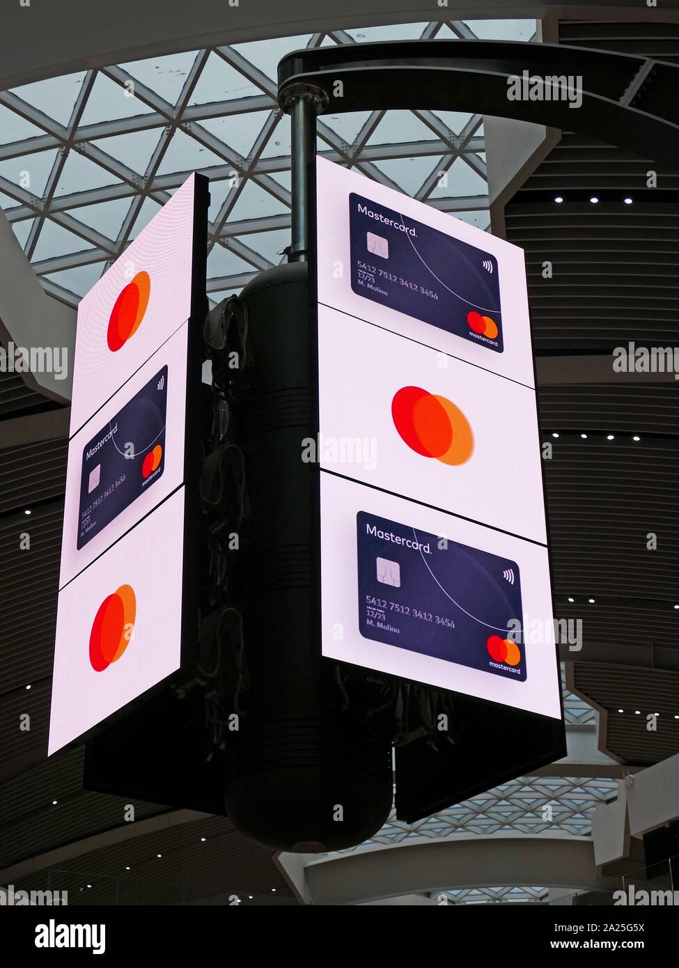 A bank of digital television screens in the departures terminal of Rome–Fiumicino International Airport . The screens display sequential adverts on a regular cycle in which both adverts and screens rotate shift and re-align to create multiple or grouped images. Stock Photo