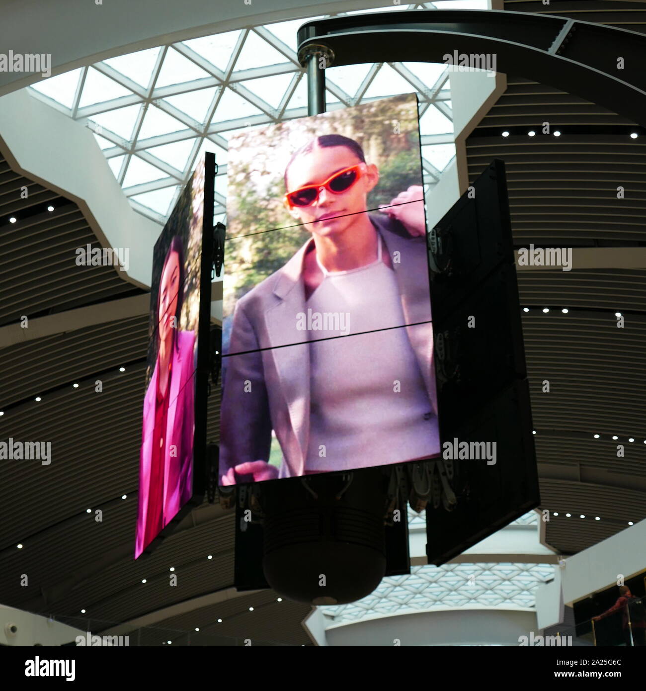 A bank of digital television screens in the departures terminal of Rome–Fiumicino International Airport . The screens display sequential adverts on a regular cycle in which both adverts and screens rotate shift and re-align to create multiple or grouped images. Stock Photo