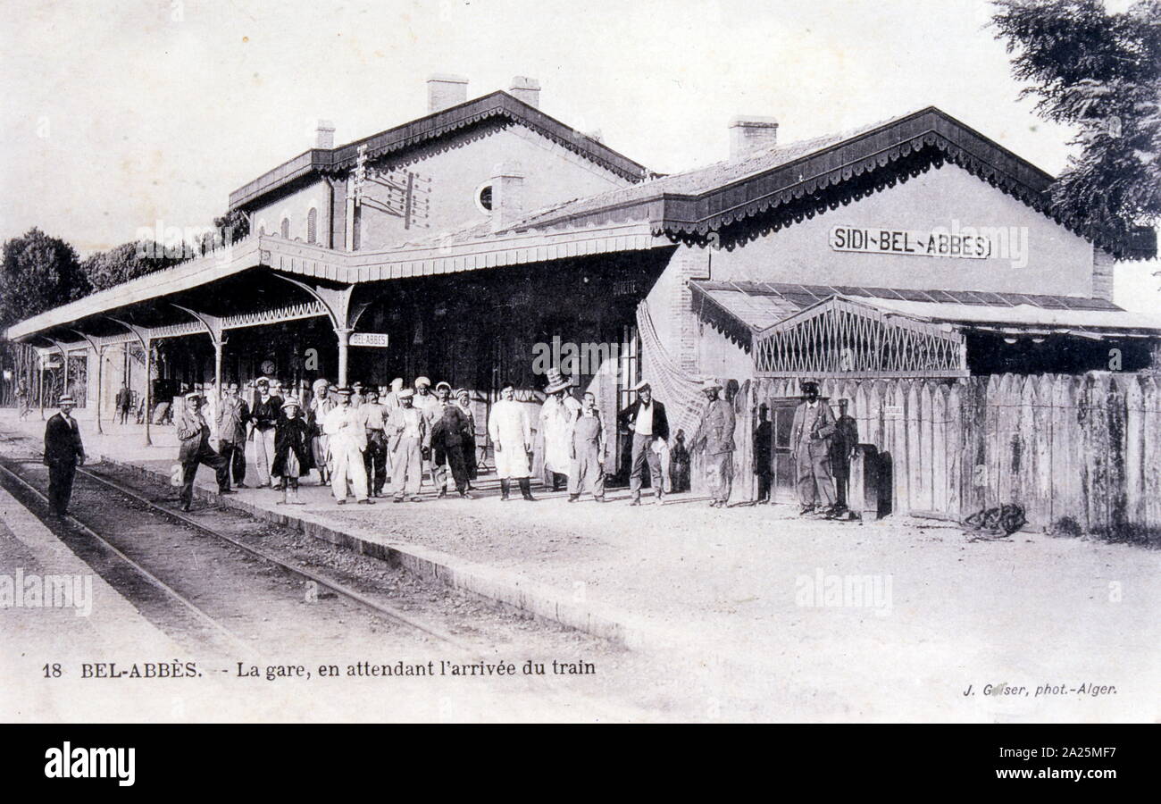 French colonists waiting for a train at the railway station in Sidi Bel Abbès, Algeria. postcard 1908 Stock Photo