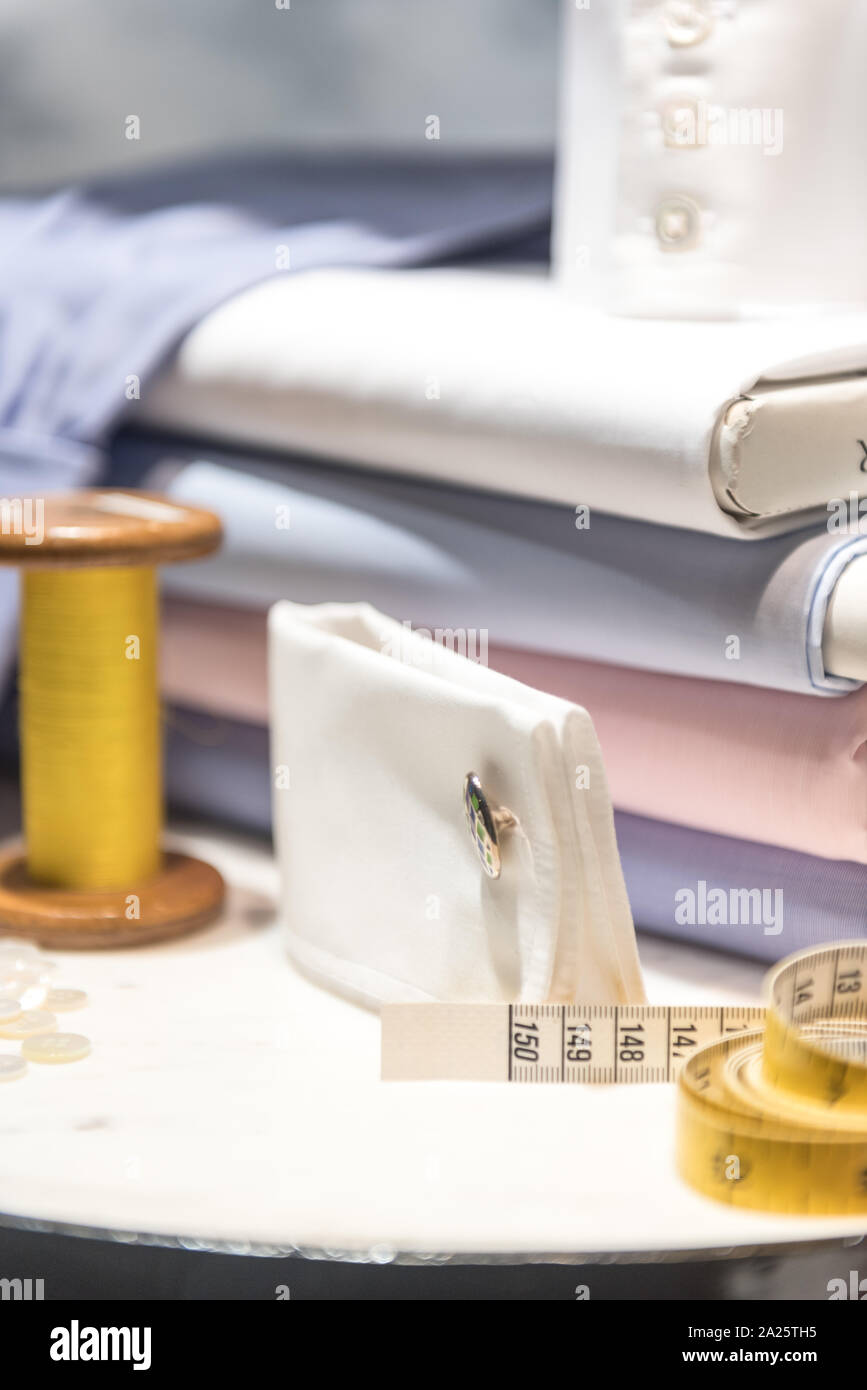 Tailor's Table with Thread and Tape Measure and Shirt Cloth Swatches Stock Photo