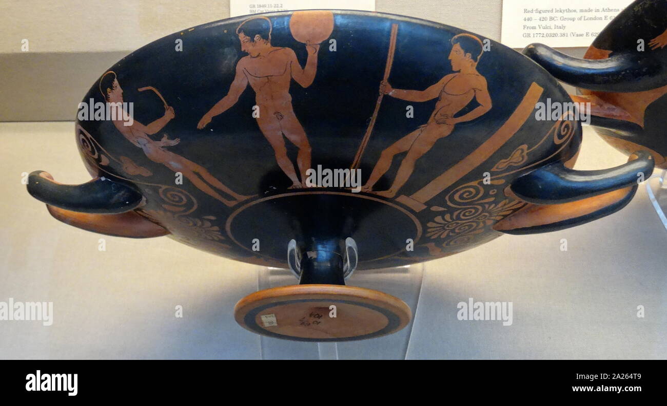 Greek red and black Krater (vase), depicting athletes training. On the left, the youth holds a strigil to scrape oil and dirt off his skin after exercise. In the middle is a young man holding a discus, on the right, a third youth, standing in front of a stele, holds two javelins. All three athletes wear victor’s ribbons. Athenian, 430 BC Stock Photo