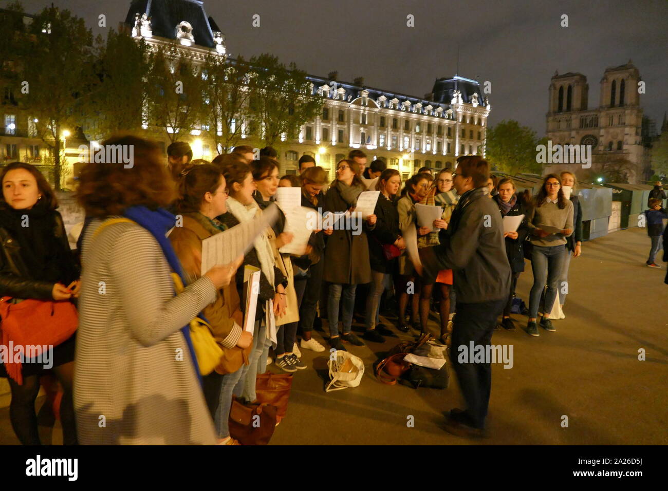 A spontaneous street choir sings Catholic liturgical songs to offer supplication and comfort near the now unlit Cathedral. Stock Photo