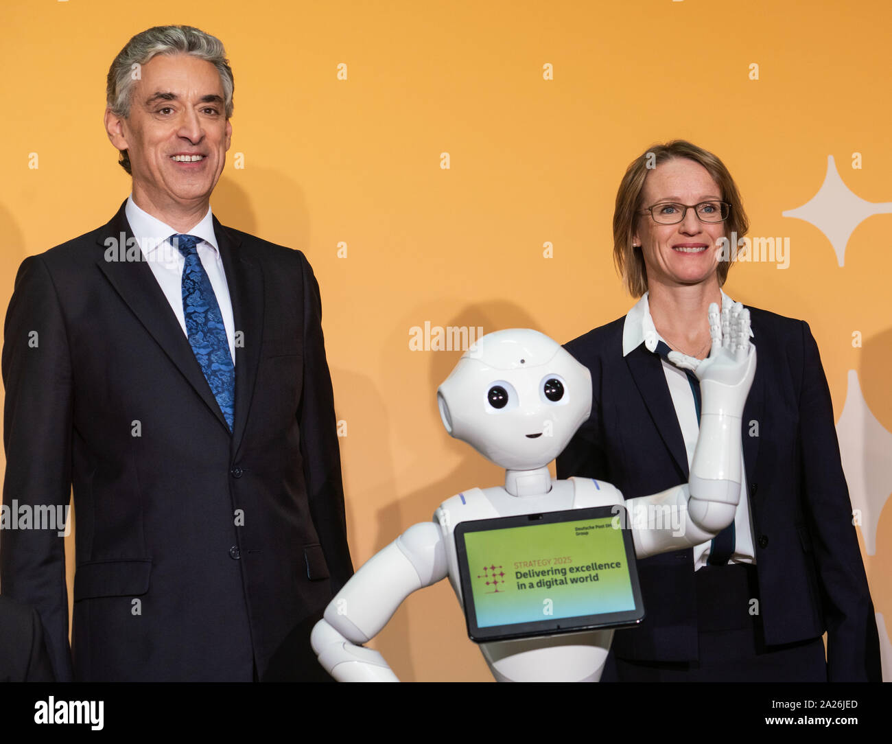 01 October 2019, Hessen, Frankfurt/Main: Frank Appel (l), CEO of Deutsche Post AG, and Chief Financial Officer Melanie Kreis (r) stand next to a robot at a photo shoot before the start of a press conference before presenting Deutsche Post's strategy up to 2025. Every five years, the Bonn-based Group updates its approach. Photo: Frank Rumpenhorst/dpa Stock Photo