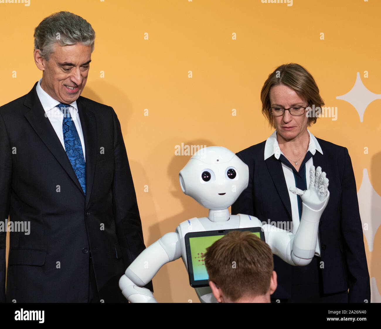 01 October 2019, Hessen, Frankfurt/Main: Frank Appel (l), CEO of Deutsche Post AG, and Chief Financial Officer Melanie Kreis (r) stand next to a robot at a photo shoot before the start of a press conference before presenting Deutsche Post's strategy up to 2025. Every five years, the Bonn-based Group updates its approach. Photo: Frank Rumpenhorst/dpa Stock Photo