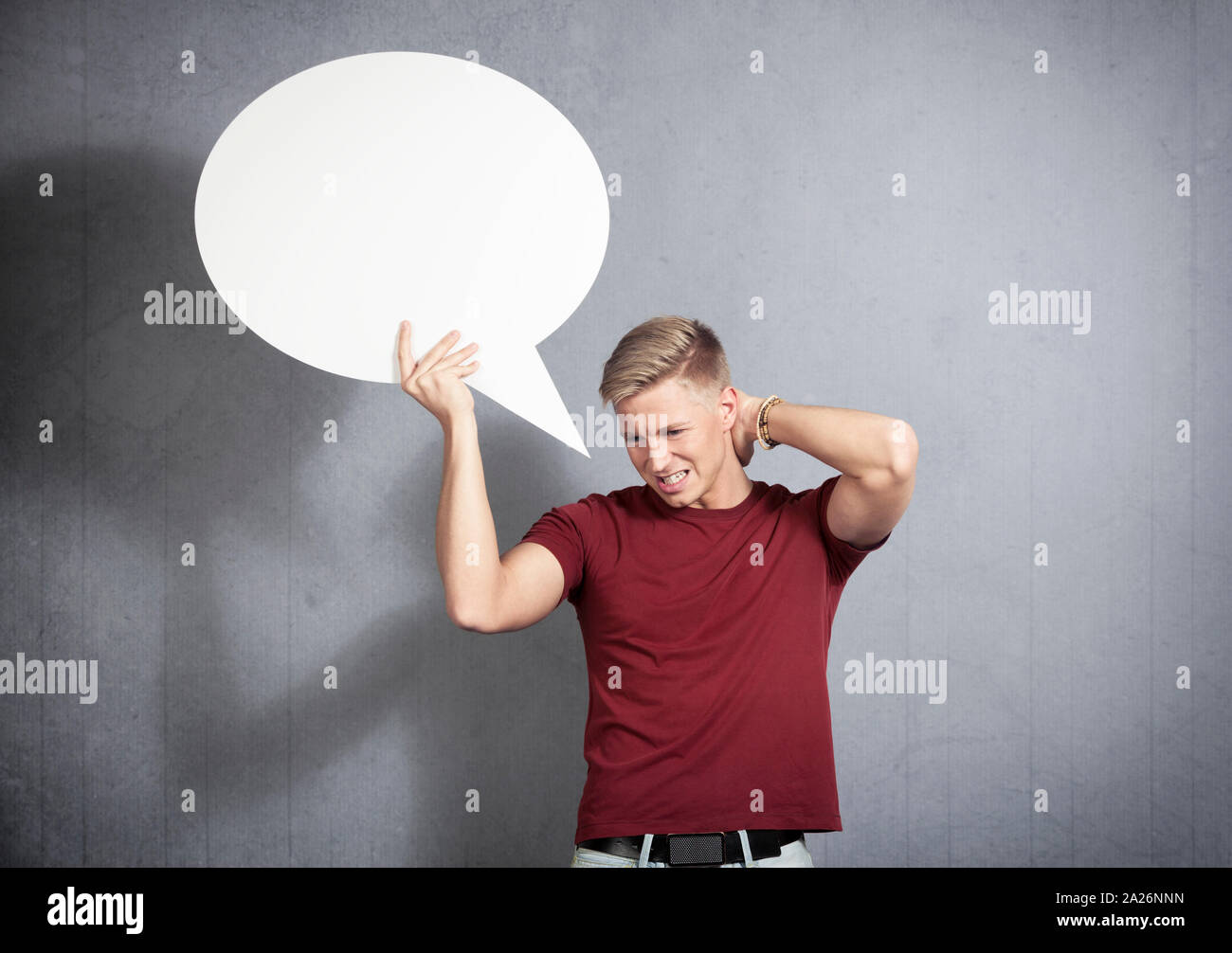 Disappointed man holding white blank speech balloon. Stock Photo