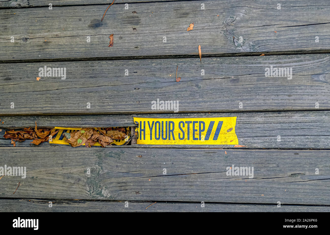 Watch Your Step Tape Over Break in Walkway Stock Photo