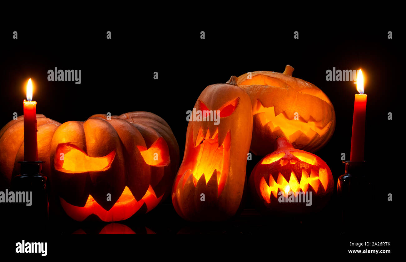 Photo of halloween pumpkins with burning mouths, candles on empty black ...