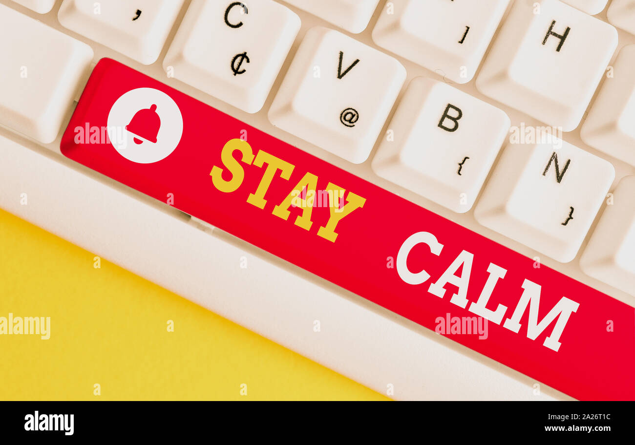 Text sign showing Stay Calm. Business photo showcasing Maintain in a state of motion smoothly even under pressure White pc keyboard with empty note pa Stock Photo