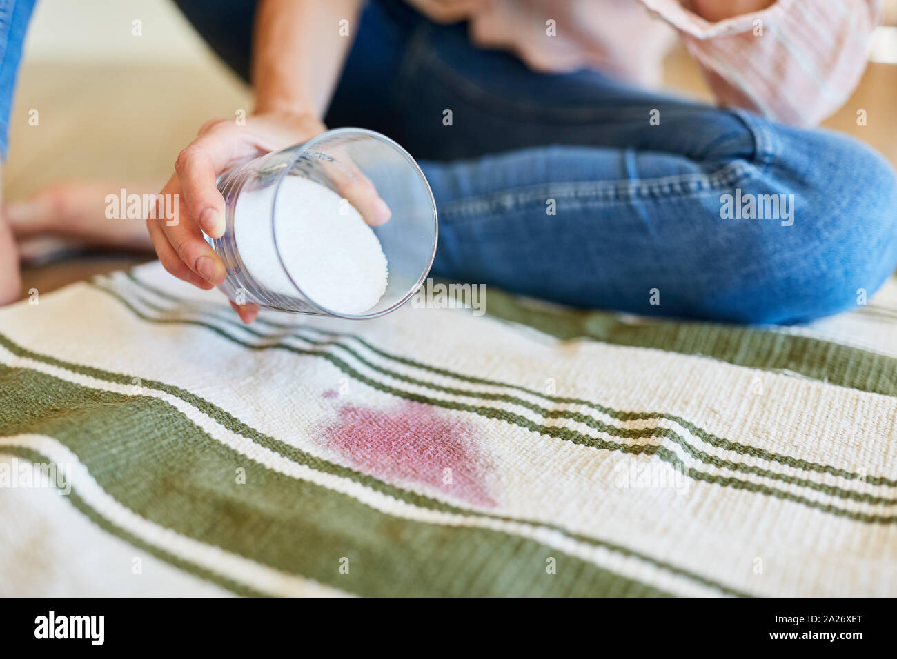 Salt as a home remedy against red wine stains on the carpet in the living room Stock Photo