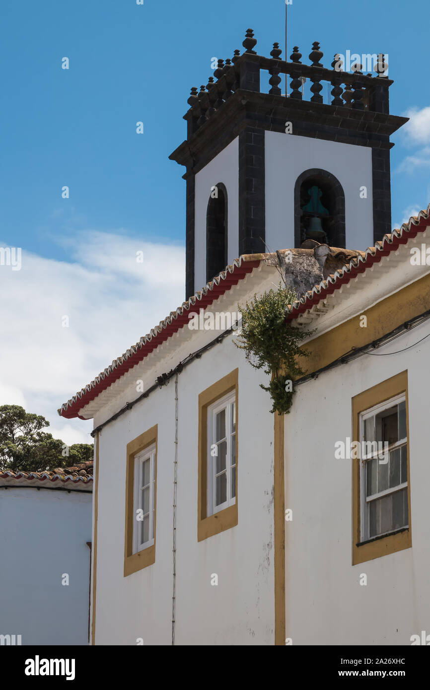 Characteristic tower of the City hall, with white facade and square shape. Belfry in the upper part. Blue sky. Ribeira Grande, Sao Miguel, Azores Isla Stock Photo