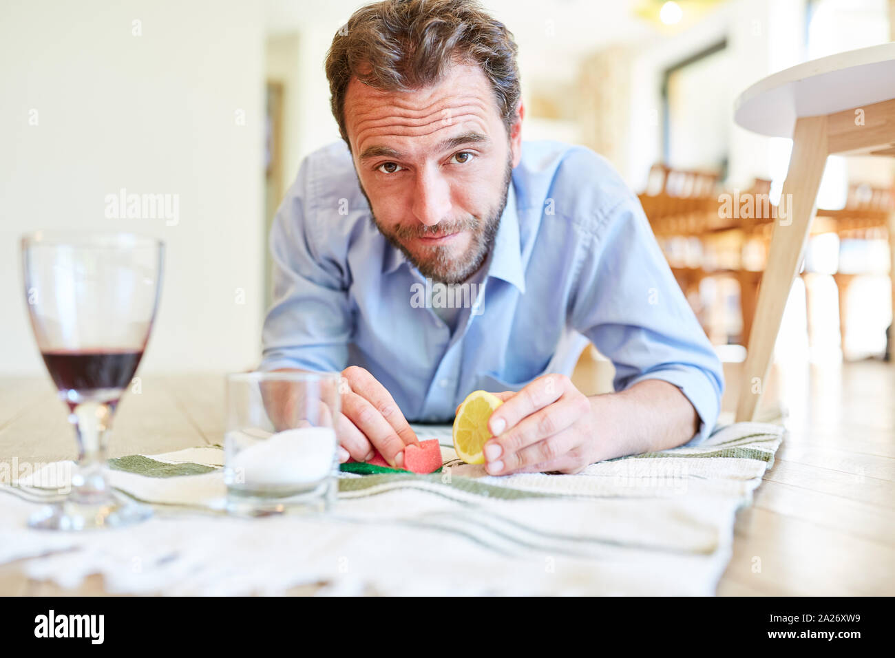 Hausmann as a cleaning man removing red wine stains with lemon and salt Stock Photo