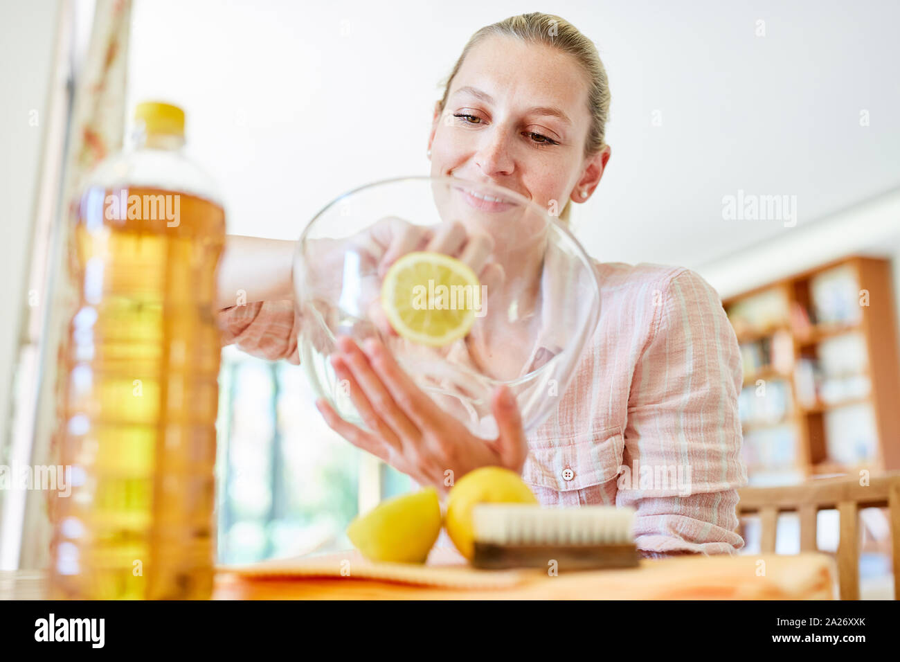 Housewife cleans glass bowl with citric acid as a cleanser and home remedy Stock Photo