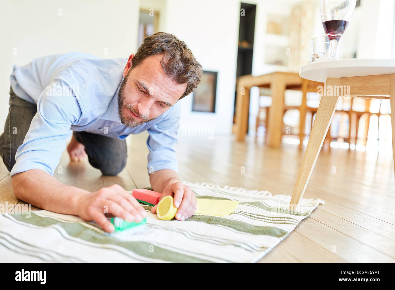 House man with lemon and salt at the red wine stain removal for role reversal Stock Photo