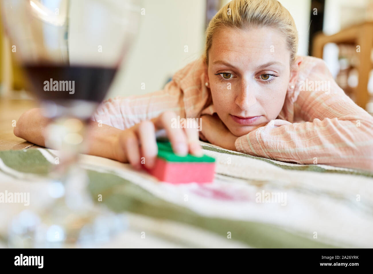 Housewife lies on carpet and removes with salt and sponge red wine patches Stock Photo