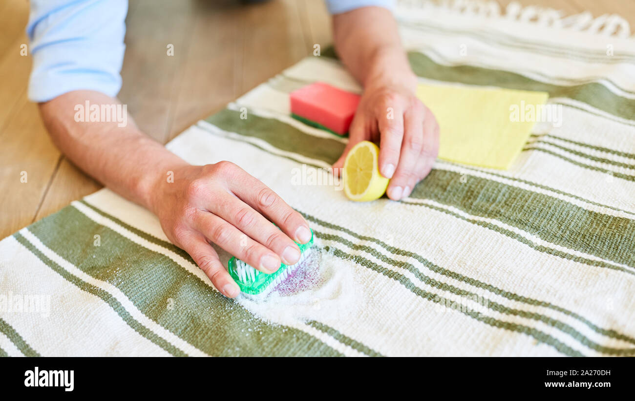 Remove red wine stain from the carpet with lemon and salt and a brush Stock Photo