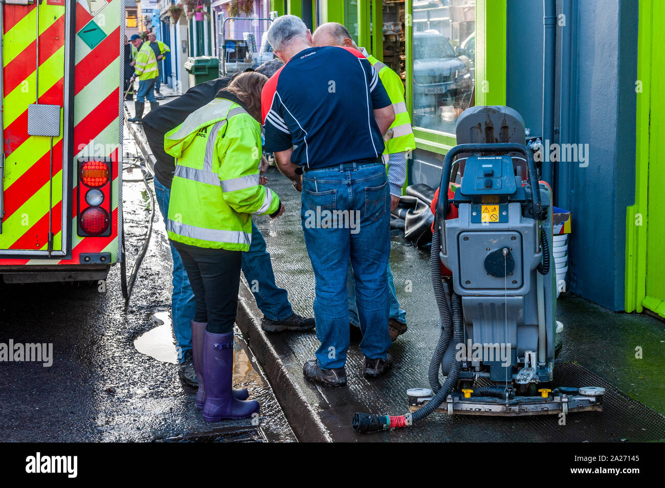 Schull, West Cork, Ireland. 1st Oct, 2019. Shops in Schull Main Street were hit badly by muddy flood waters this morning. At approximately 4am, drains in the street couldn't handle any more torrential rain and, due to being blocked with leaves and silt, overflowed causing a number of shops to flood. Cork County Council employees inspected the damage to the shops. Credit: Andy Gibson/Alamy Live News. Stock Photo