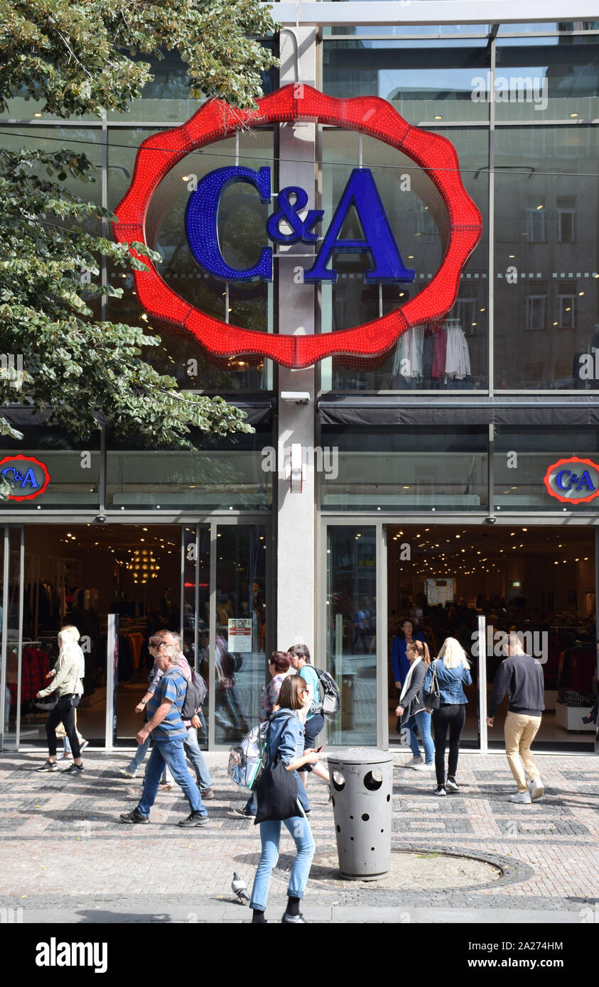 Logo of 'C&A', in red and blue, on a storefront, with people shopping. C&A  is an international chain of fashion retail clothing stores Stock Photo -  Alamy