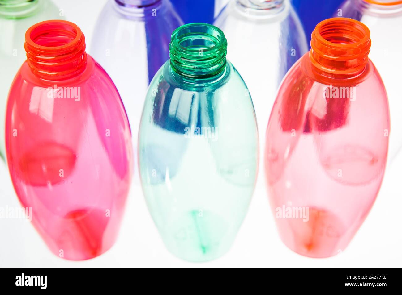 colored plastic bottles syde by syde on a translucent surface Stock Photo