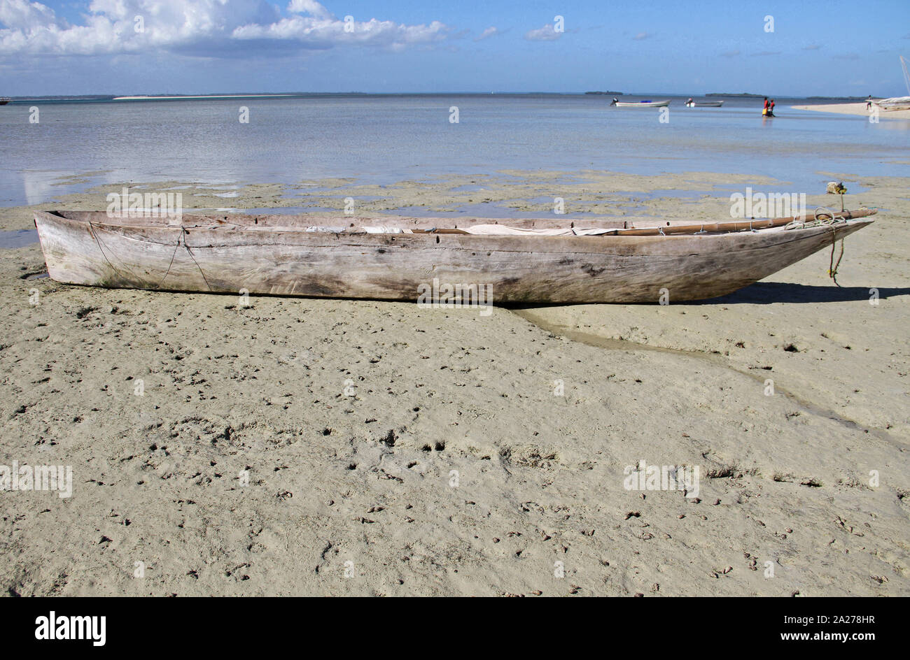 Old empty wooden fishing canoe on beach with mast down, Zanzibar ...