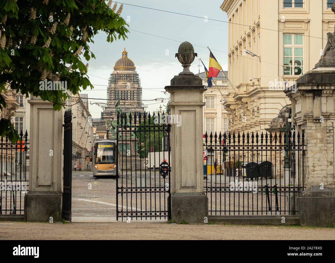 Shot through the gate of Brussels park in historic city centre of passing tram and cars Stock Photo