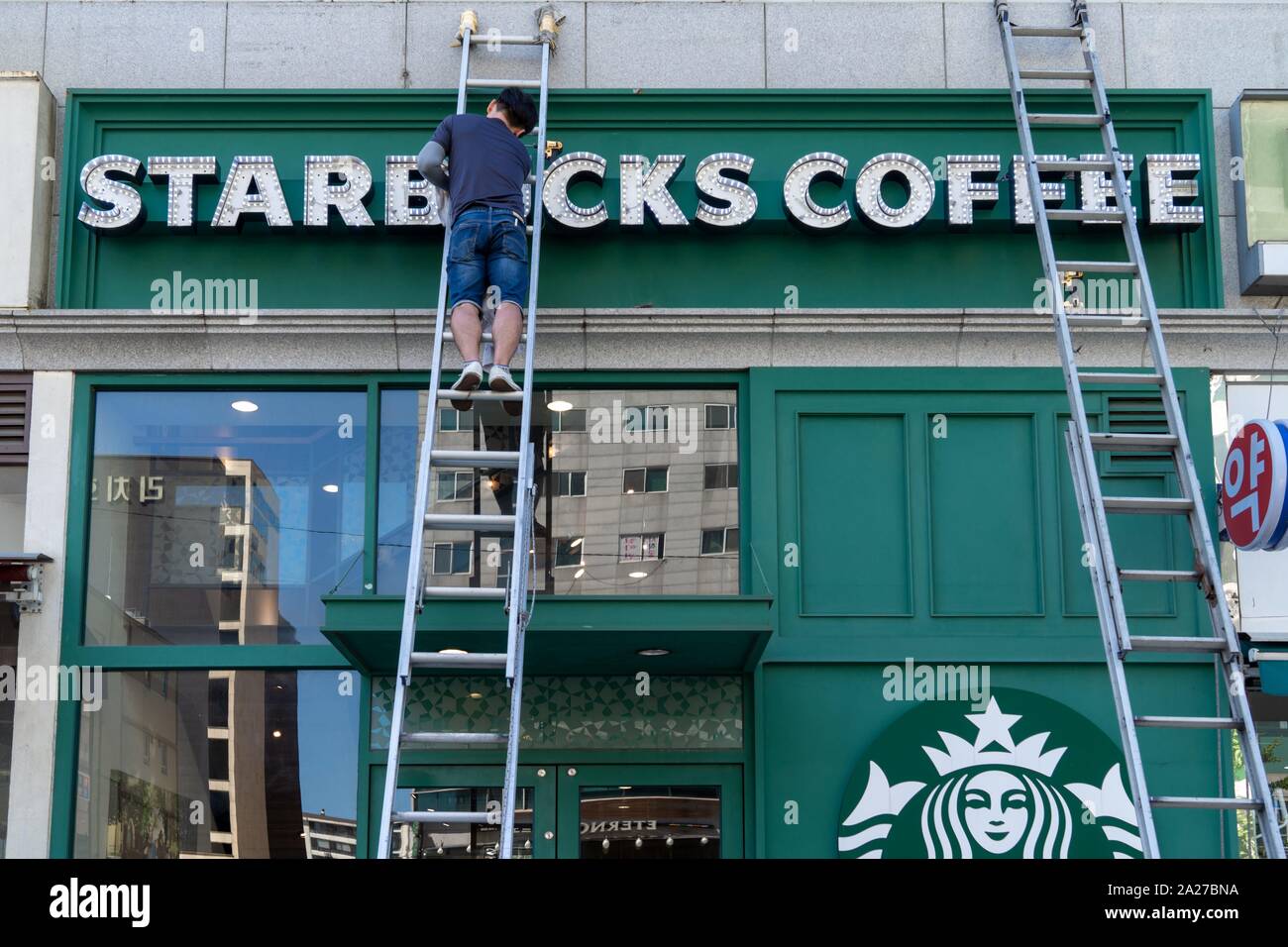 South Korea: Worker cleans Starbucks sign at a location in central Seoul.Photo from 10. September 2018. | usage worldwide Stock Photo