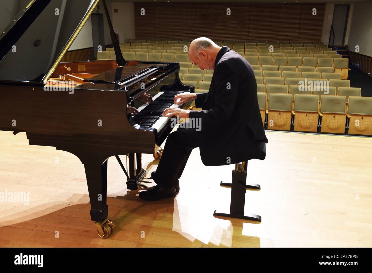 Pianist Till Engel, professor at the Volkwang-Hochschule Essen/Duisburg,  sits on a grand piano at a photo shoot on 27 September 2019 in Düsseldorf  on the stage of the Clara-Schumann-Musikschule. | usage worldwide