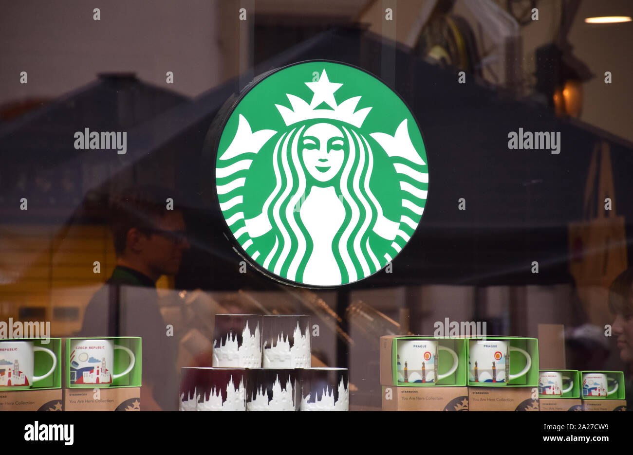 Green logo of 'Starbucks Coffee' on a storefront in the centre of