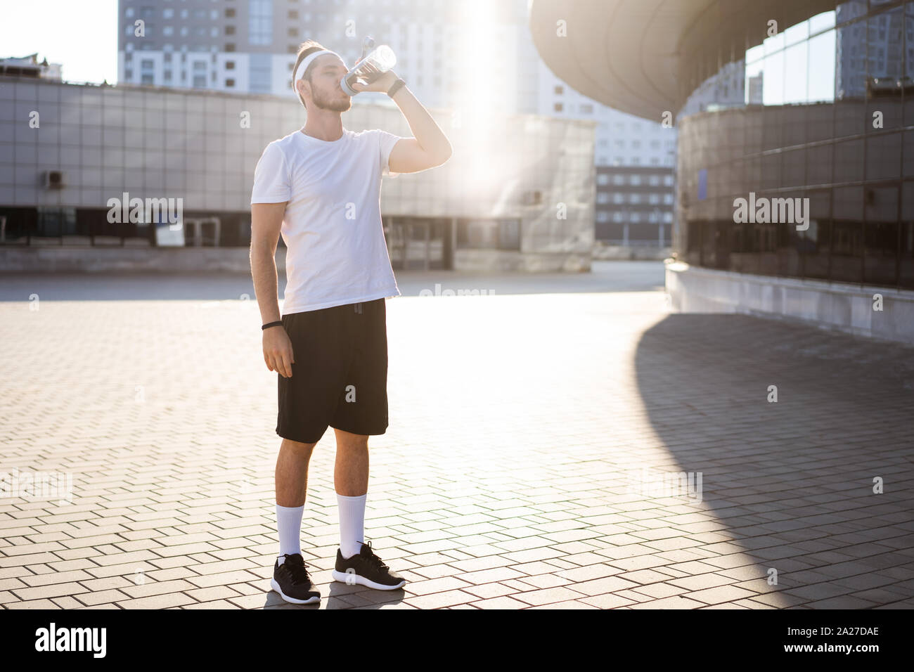 Thirsty athlete drinking water after workout Stock Photo Alamy