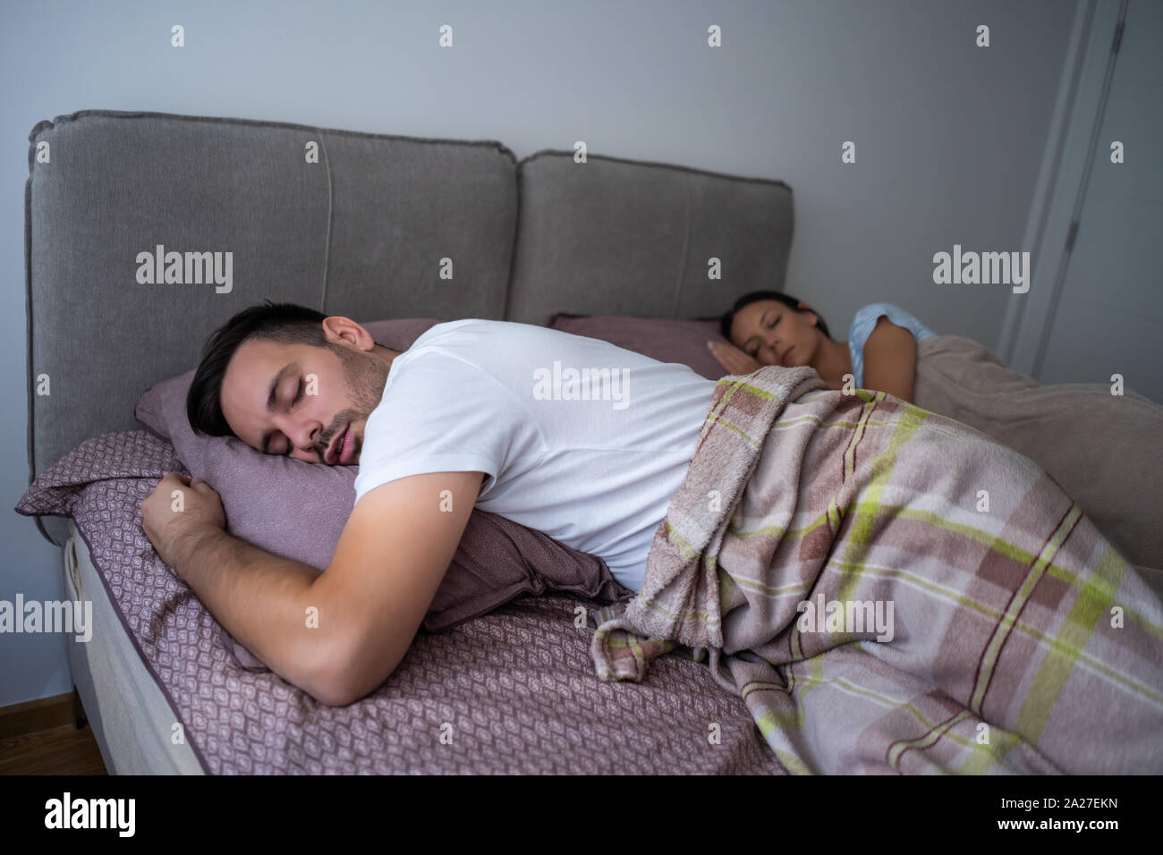 Young couple is sleeping in their bed. Stock Photo