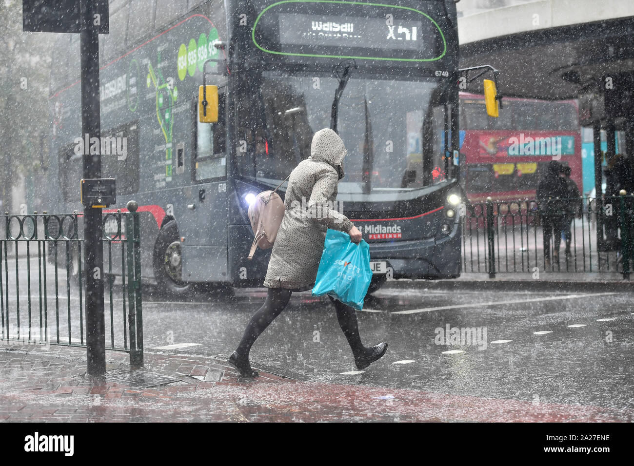 People make their way through a heavy rain shower in Birmingham Stock