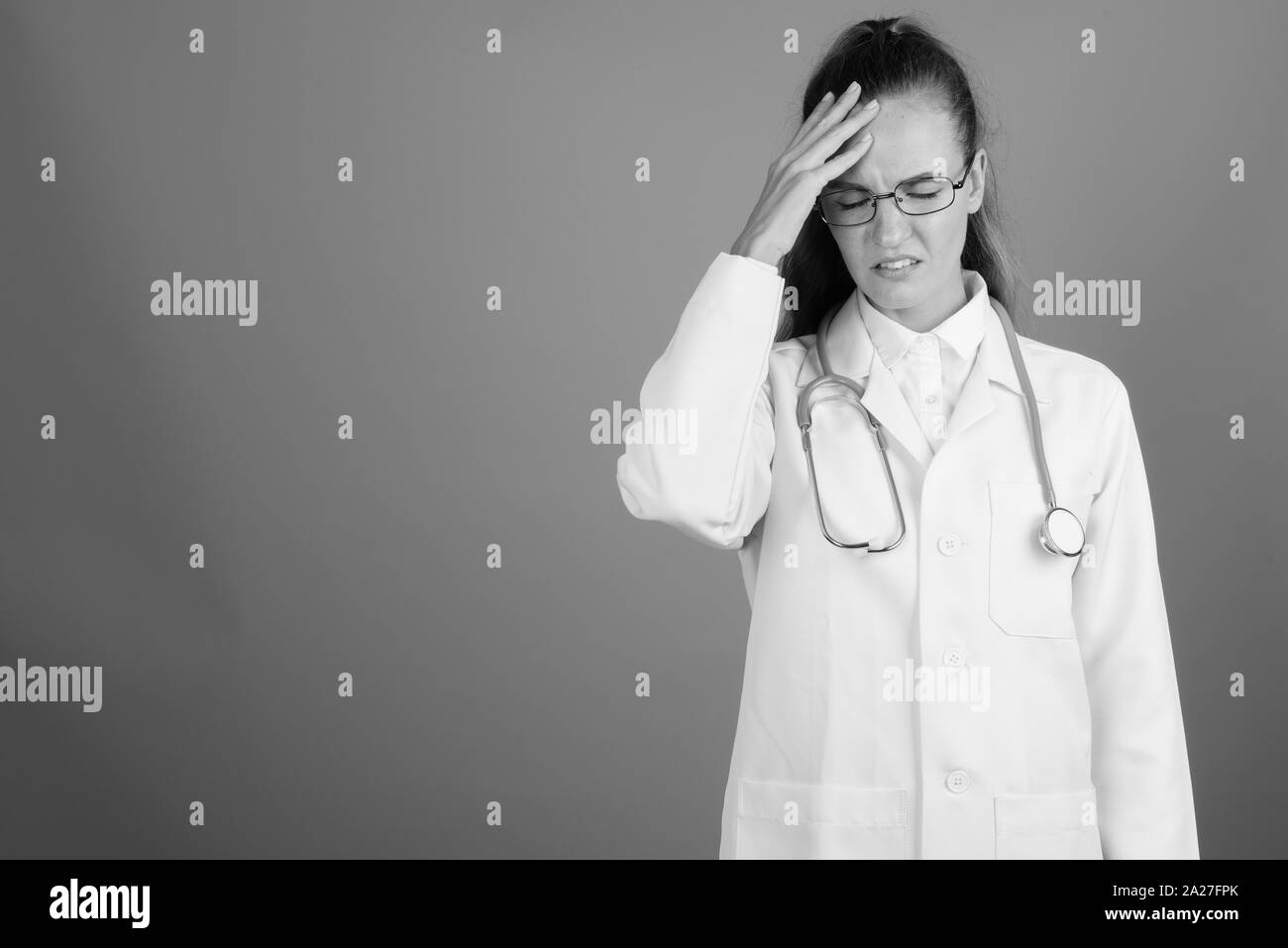 Stressed and sad woman doctor against gray background Stock Photo