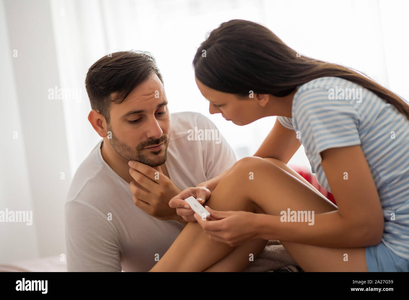 Young couple is anxious anticipating result of pregnancy test. Stock Photo