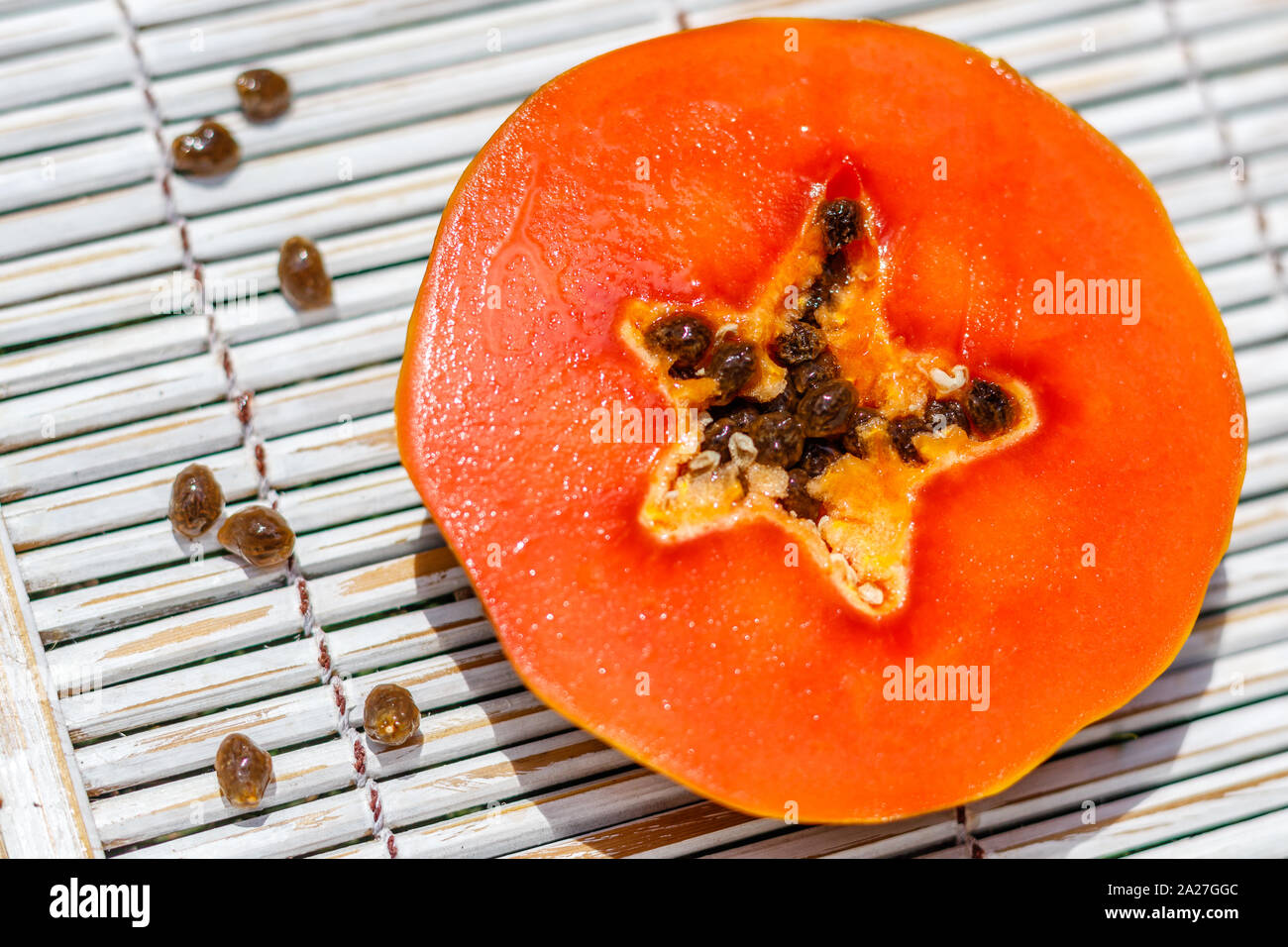 Fresh papaya cut in round pieces, with a star shape middle. Female hand
