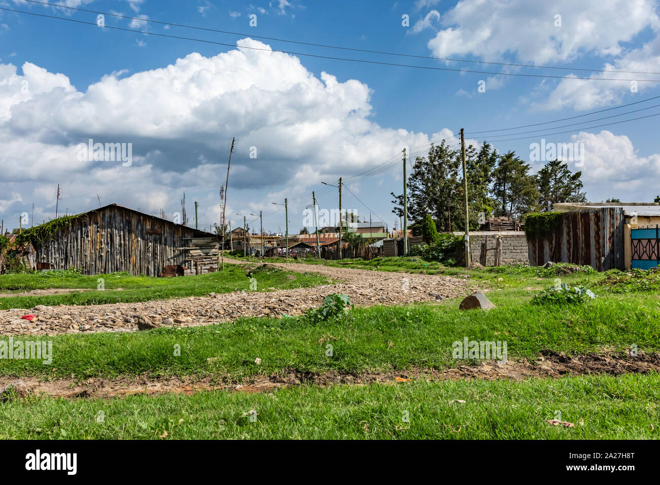 Nanyuki, Laikipia County, Kenya – June 19th, 2019: Landscape photograph of stone track surrounded by typical small Kenyan homes in Nanyuki outskirts. Stock Photo