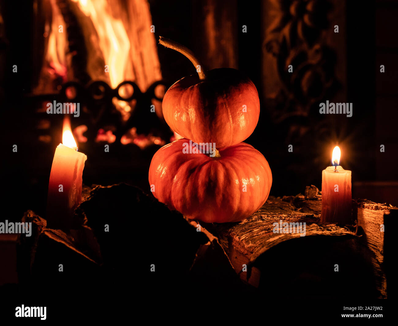 Two Halloween Pumpkins Standing In The Dark On Birch Logs