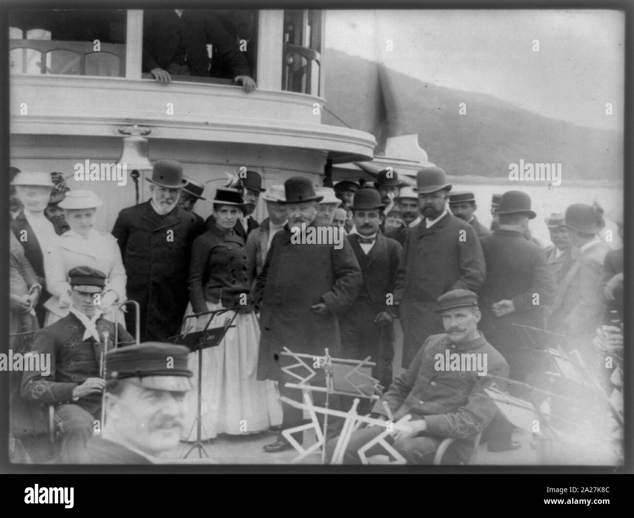 President Benjamin Harrison with James G. Blaine, Secretary of State, Henry Cabot Lodge, and group of other people posed, possibly on the forward deck of the Frenchman's Bay steamer Sappho, with several men of the Bar Harbor Band, Maine() Stock Photo