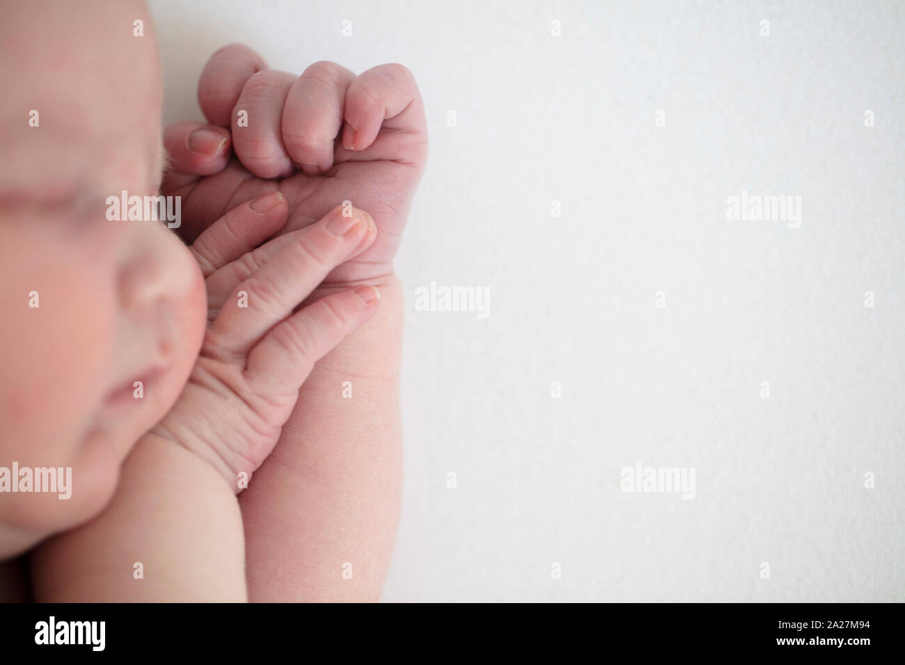 Close up of a cute sleeping baby resting on their arms Stock Photo