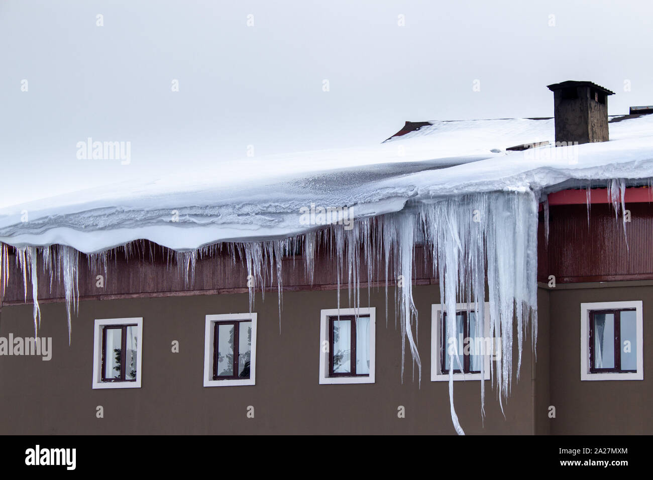 Large Icicles Hanging From The Roof Of The Building Cold Weather And Heavy Snowfall Stock Photo Alamy