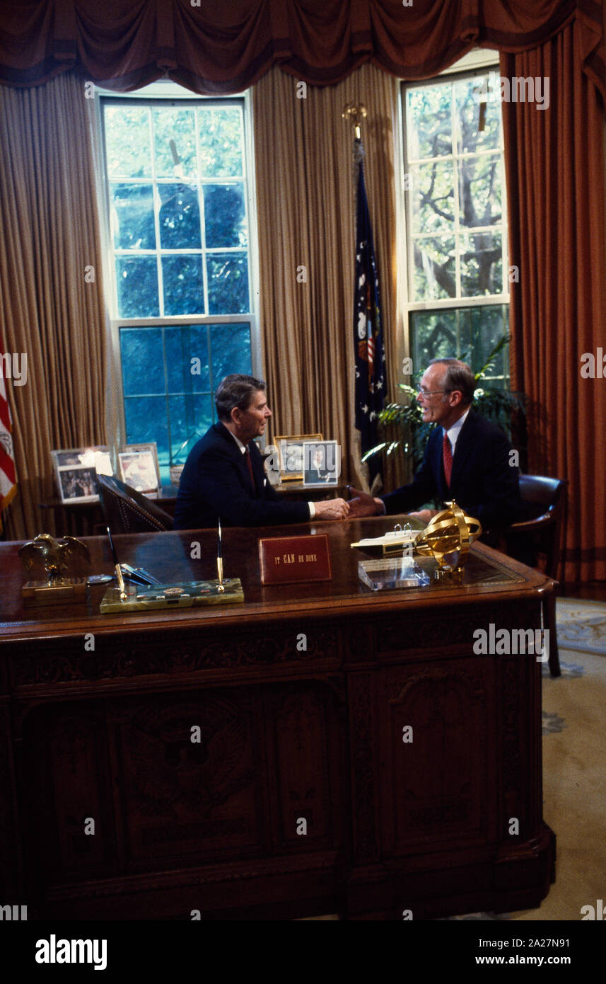 President Ronald Reagan talks to Republican Senators at his desk in the ...