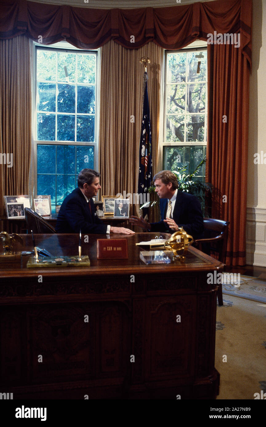 President Ronald Reagan talks to Senator Dan Quayle at his desk in the ...