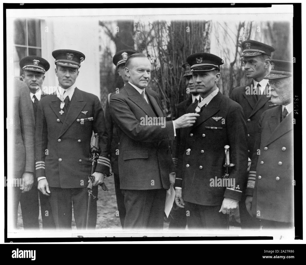 President Coolidge today conferred the Congressional medal on Commander Byrd and Machinist Bennet sic; President Coolidge awarding medal to Floyd Bennett as Richard Byrd stands at left, looking on with others.; Stock Photo