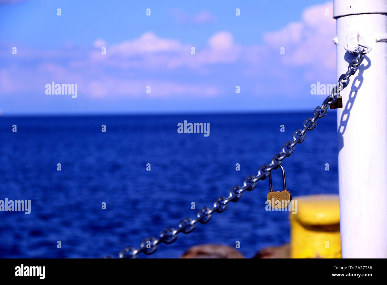 A heart-shaped padlock on the iron chain Stock Photo