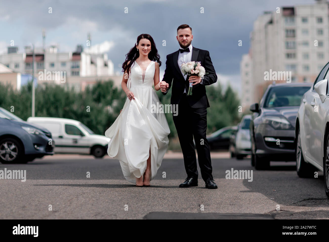 happy bride and groom walking down the street in the big city Stock ...